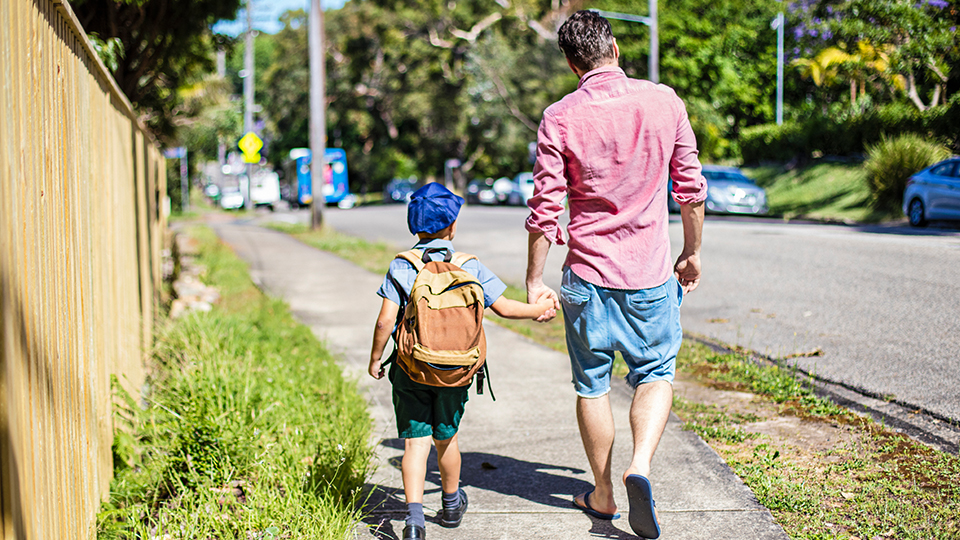 Man and child walking on footpath